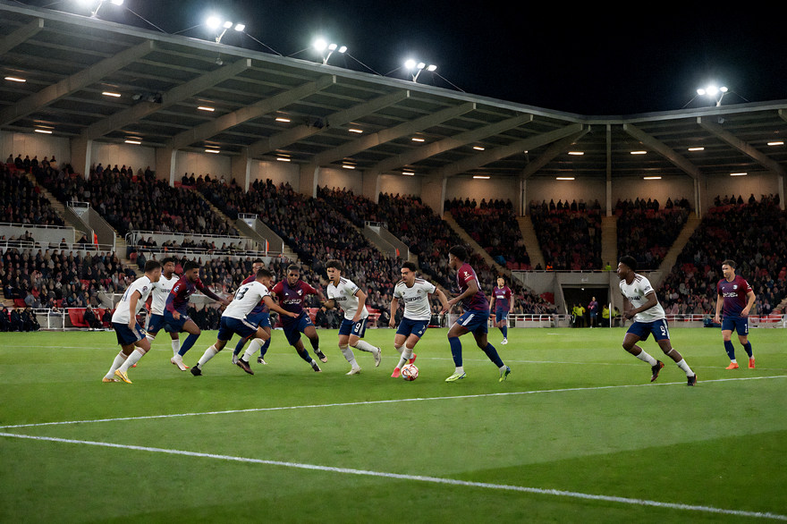 夜间灯光球场中正在进行的足球比赛现场画面